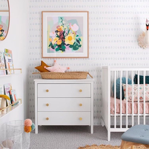 A light neutral nursery with light blue moon phase wallpaper