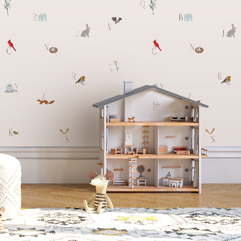 A children's room with wooden dollhouse and subtle alphabet wallpaper