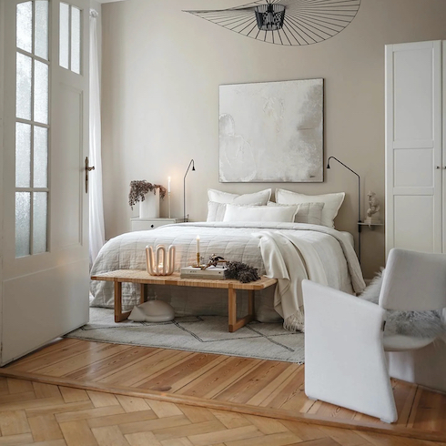 Light and airy neutral bedroom featuring Oxfordshire, England, Farrow & Ball's new Oxford Stone No. 264, wood floors and a cream coloured bed and chair