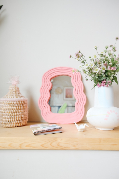 DIY pink polymer clay hand mirror displayed on wood dresser 