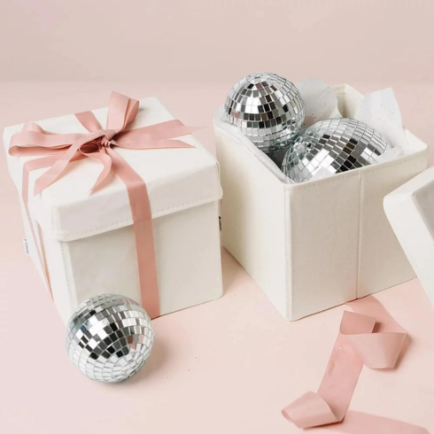 reusable white gift boxes with pink ribbon filled with silver ornaments