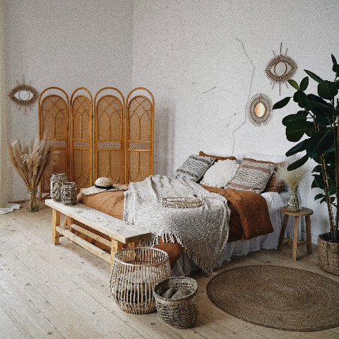 An aesthetic bedroom with natural decor made with lots of wood and rattan