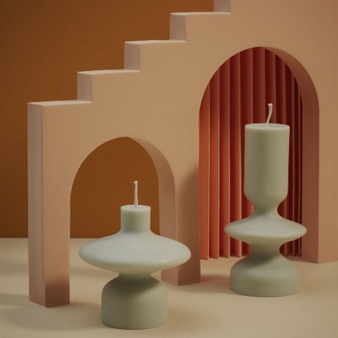 Japandi-style sculptured candles, one short and one tall, in a sage green colour