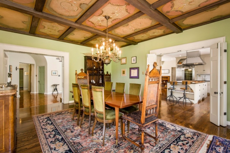 A formal dining room with antique furnishings, muraled ceiling and direct access to the kitchen