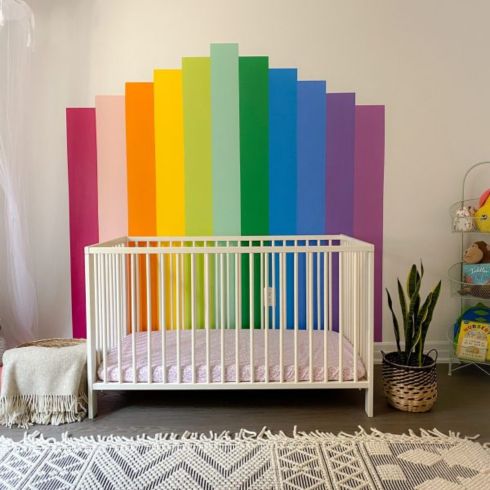Rainbow mural behind crib