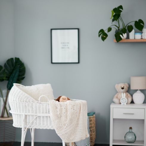 Nursery room with grey wall and sweet vintage bassinet.