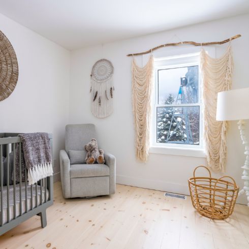 Boho inspired nursery room with vintage details and rattan accents.