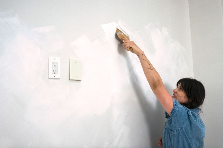 DIY expert Maca Atencio applying limewash paint look to white wall