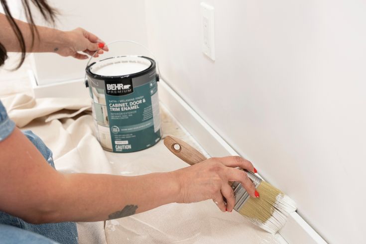 baseboards being carefully painted white