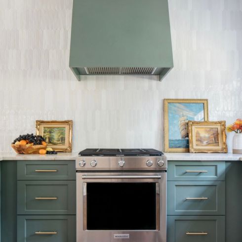 Old world art adorns the green kitchen counter