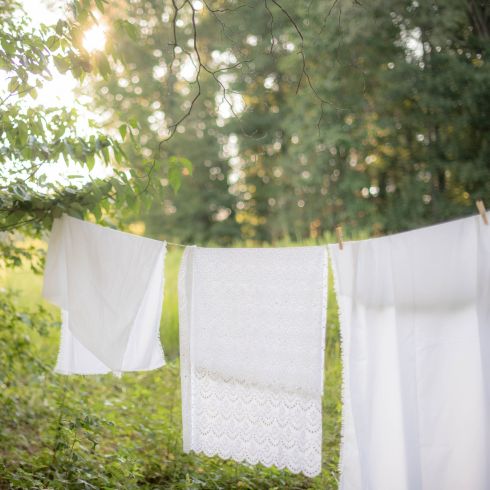 White towels hanging outside in wilderness on laundry line.