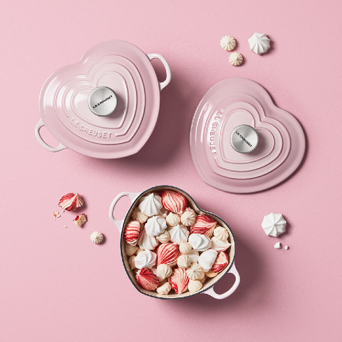 A pink heart-shaped Le Creuset cast iron cookware in a light pink