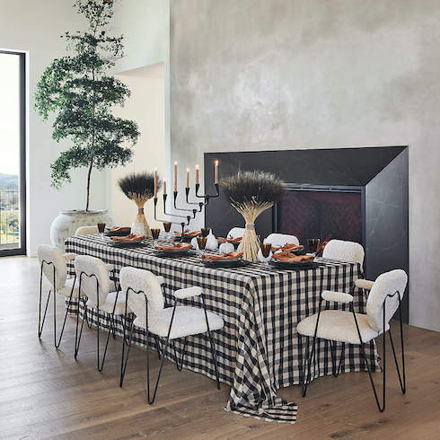 Modern dining room decorated for fall with checkered black and white tablecloth.