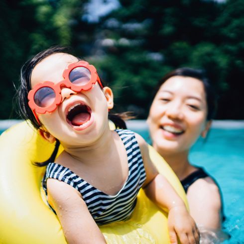 Mom holding kid in swimming pool