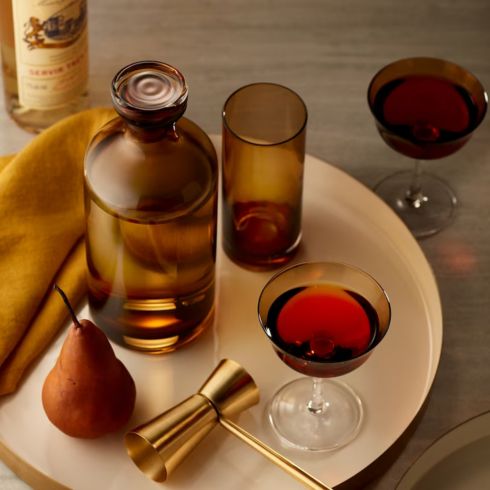 Amber glassware on white table with other cocktail accessories