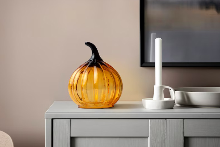 Glass pumpkin and candle on mantle