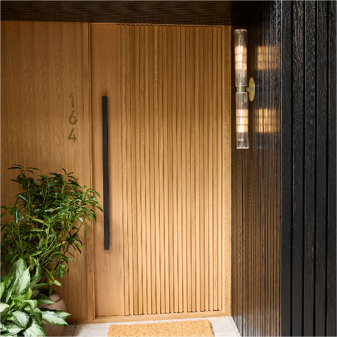 A modern front door with a wall-mounted lighting fixture