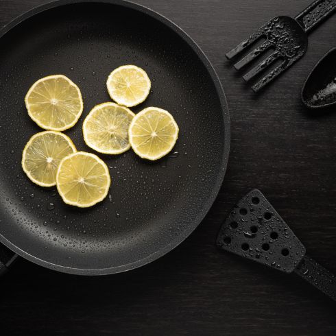 Sliced lemon in black frying pan