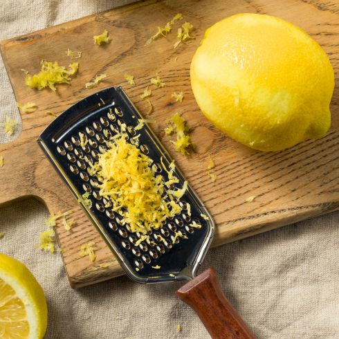 hand grater on cutting board grating lemon zest