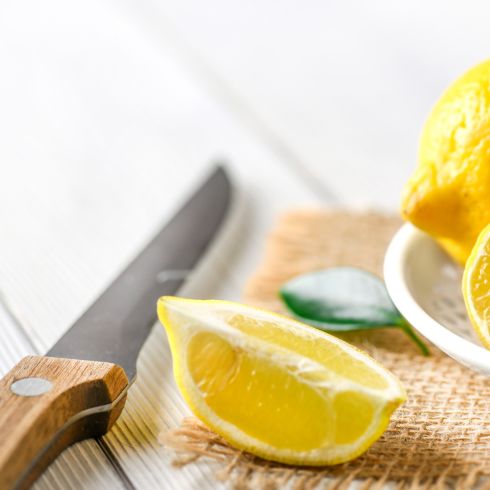 Lemon wedge beside kitchen paring knife
