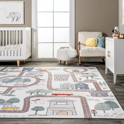 White Washable Charlie Town Map Area Rug from Rugs USA in a cute nursery with grey wood floors, a white boucle rocking chair and sheep side table, white crib, wooden owl stool, white cabinet and grey walls as featured in HGTV Canada's Best Nursery Rugs Under $200 Your Little One This Year