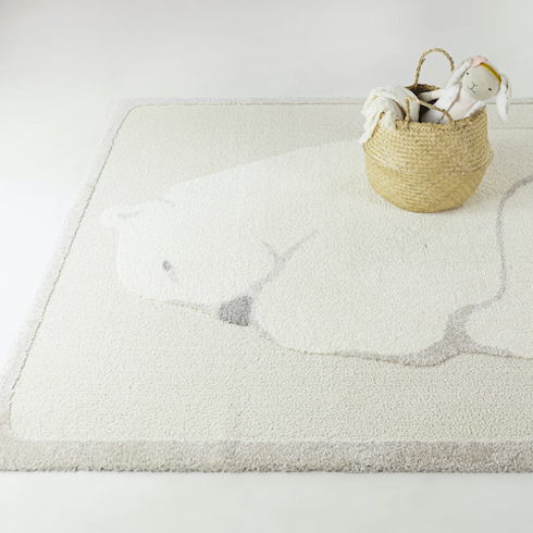 Mack & Milo Aldora Cream Kids Animal Area Rug from Wayfair featuring a white polar bear on the floor with a basket filled with sweet stuffed animals as featured in HGTV Canada's Best Nursery Rugs Under $200 Your Little One This Year
