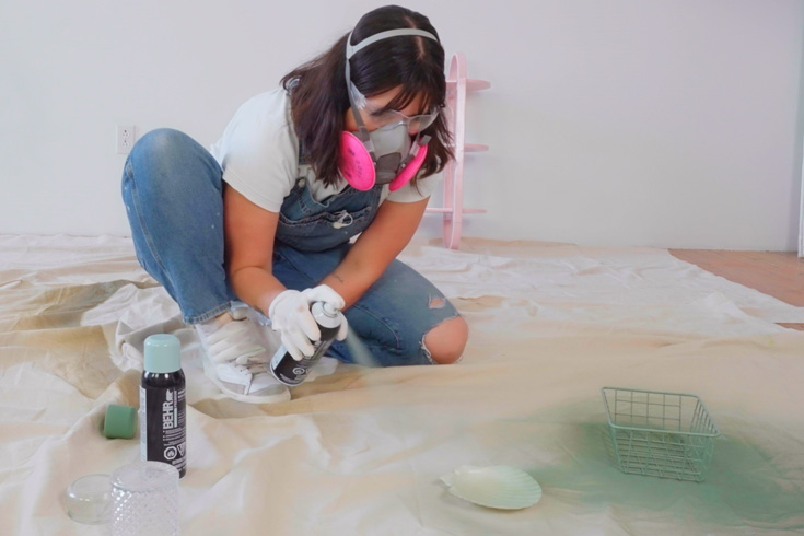 DIY expert Maca spray painting her bathroom accessories using Behr spray-paint