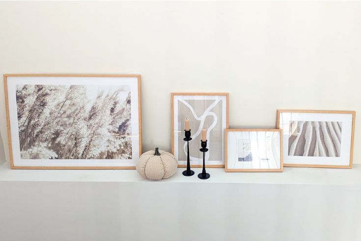 Modern white mantel with leaning artwork and faux fabric pumpkin for fall decor