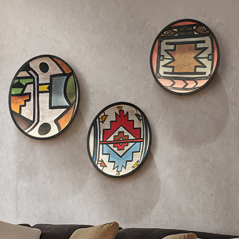 Three graphic patterned plates hung on a living room wall
