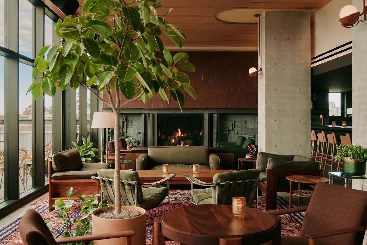 Hotel lobby seating area with fireplace, large plants, 