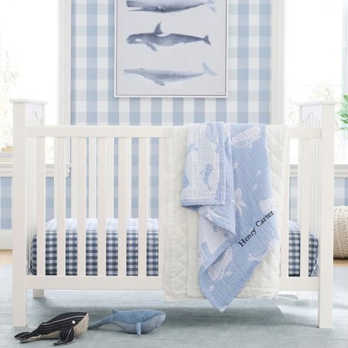 Blue and white nursery with whale artwork and ocean-inspired accents