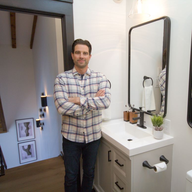 Scott McGillivray posing in a renovated bathroom