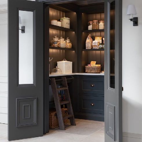 A beautifully crafted pantry designed by UK based cabinetry maker Humphrey Munson with a mix of open shelving and drawers in a dark grey colour