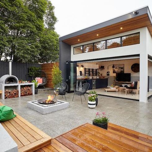 Chic indoor outdoor kitchen with stone pavers, wood decking, a fire pit, a pizza oven, a vertical garden, built-in bench seating designed by the team at Bunnings Warehouse. You’ve got to see the sad, unwelcoming state of this terrace before the makeover.