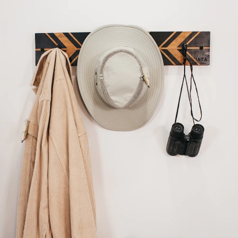 A rustic wooden coat rack with black accents