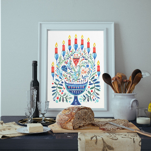 Canadian holiday decorations - An illustrated print of a lit menorah framed on a dining table