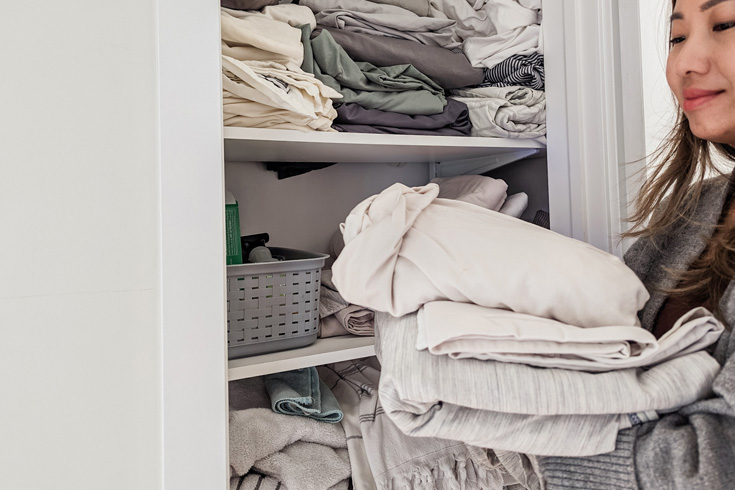Woman organizing a small linen closet