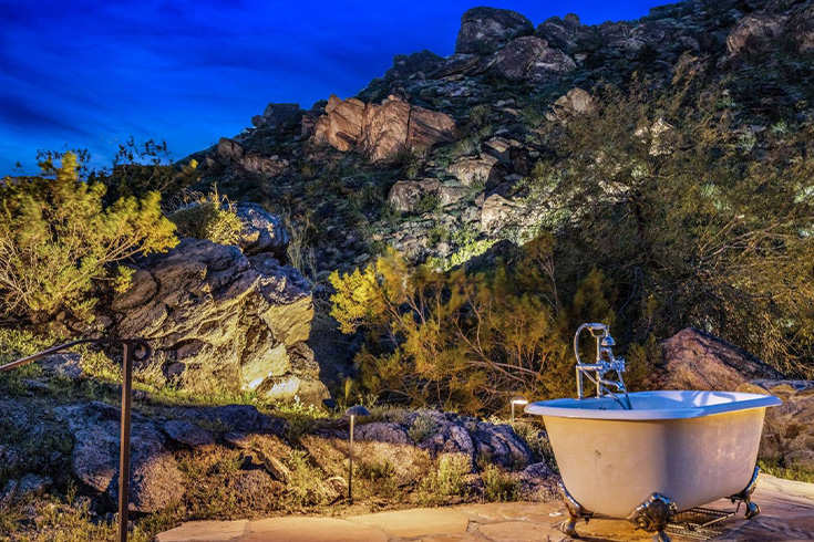 Outdoor bath tub with mountains in the background