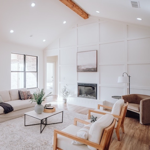 A spacious white living room with windows on one wall