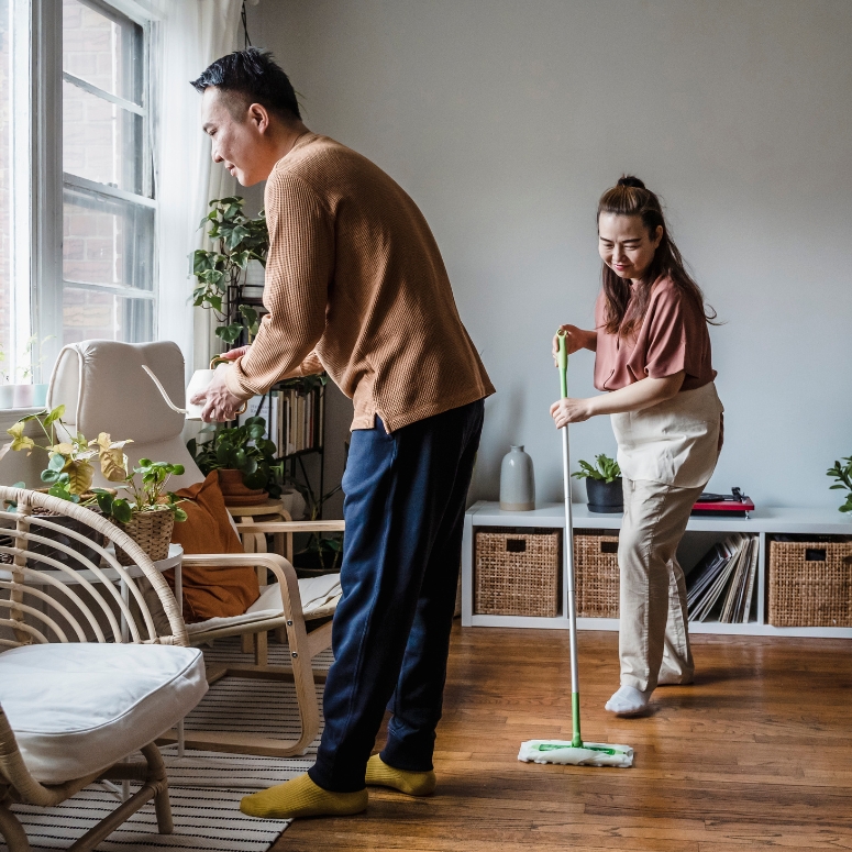 A man and woman cleaning their living room together