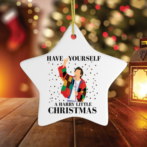 a white star ornament with a cartoon image of Harry Styles, text saying Have yourself a harry little christmas