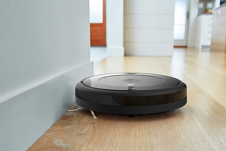 iRobot Roomba Robot Vacuum cleaning dust bunnies off a hardwood floor