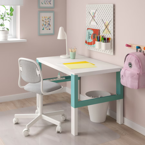 a small kid's desk in a pink bedroom
