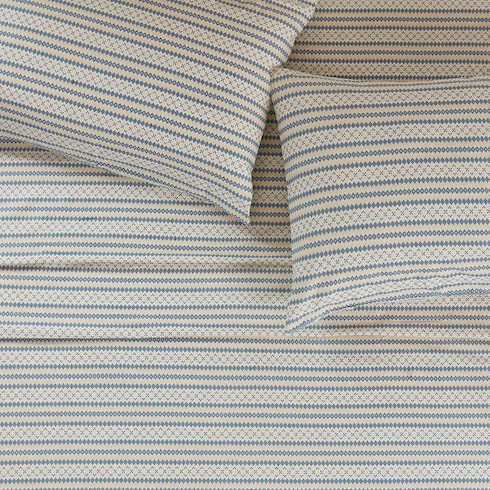 Woolrich Flannel Sheet Set made with 100 per cent cotton featuring a Nordic themed geometric pattern of creams, whites and blue on a made bed with two pillows