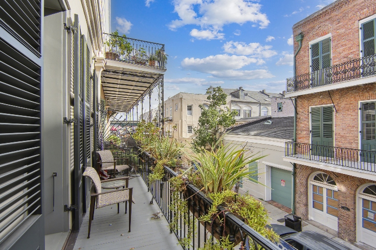 A balcony with chairs overlooking the French Quarter in New Orleans