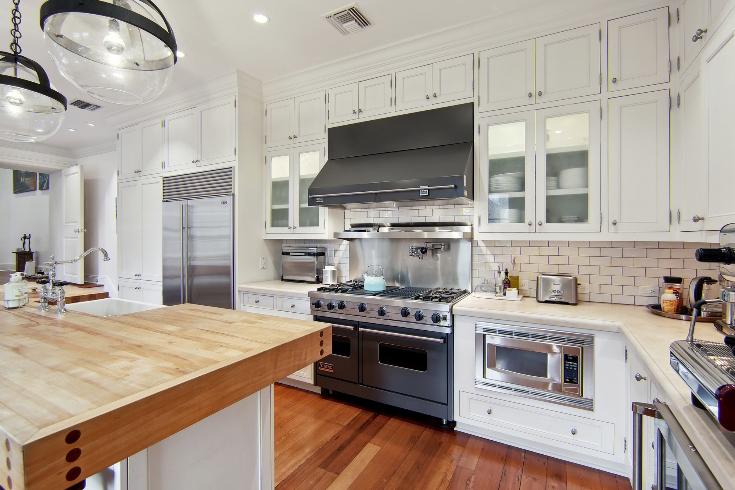 A gourmet chef’s kitchen with Viking stove, two ovens, wine cooler, Sub-Zero refrigerator, butcher’s block island, marble counters and pantry.