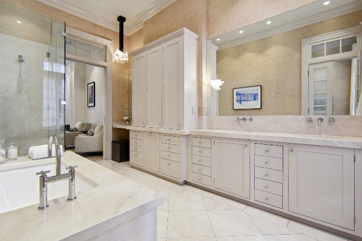 A marble bathroom with frameless glass shower, oversized tub and double vanities.