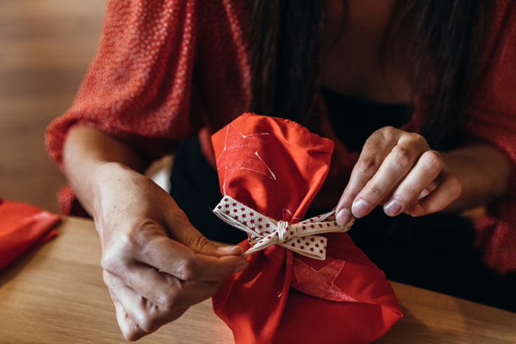 How to gift wrap like a pro - woman wrapping awkward shaped present for Christmas