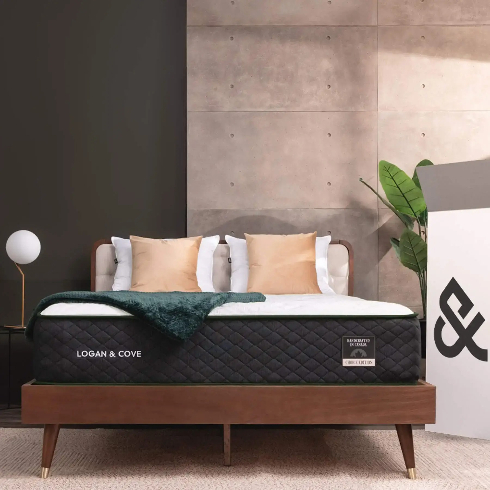 A Logan and Cove mattress on a dark wooden bed in a jade green bedroom