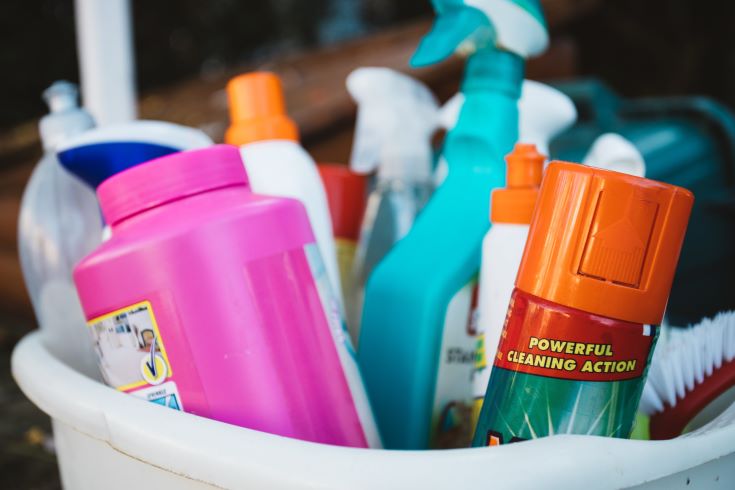 A bucket of various cleaning products